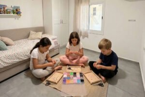ילדים יוצרים צמידים מחרוזים בחדר - פעילות יצירת תכשיטים בבית